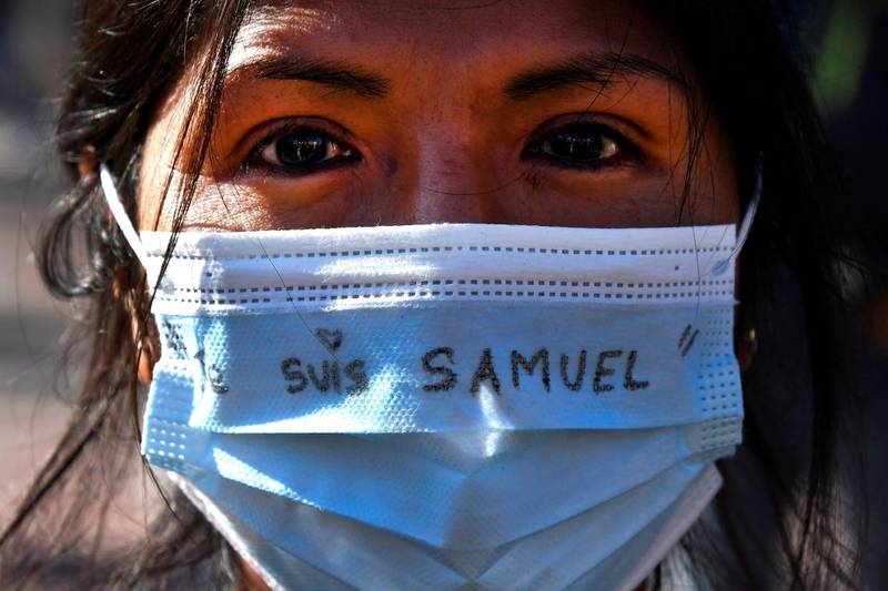 A person wears a prtotective face mask with an inscription reading 'I am Samuel'.  AFP
