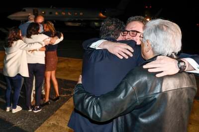 Family members embrace freed Americans Siamak Namazi, Morad Tahbaz and Emad Shargi, as well as two returnees whose names have not yet been released by the US government after a prisoner swap deal with Iran. AP