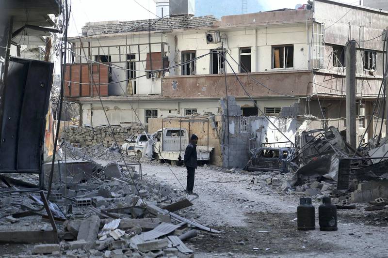 A Syrian man stands next to rubble in a heavily-damaged street next to a destroyed hospital that was hit by a reported regime air strike in the rebel-held enclave of Hamouria in the Eastern Ghouta near Damascus on February 21, 2018. (Photo by ABDULMONAM EASSA / AFP)