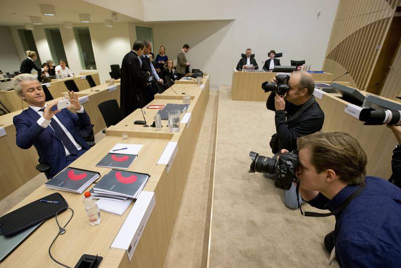 Firebrand Dutch lawmaker Geert Wilders, left, takes pictures of photographers as he appeared in court for a pretrial hearing at a high-security court on charges of inciting hatred, in Amsterdam, Netherlands.  AP