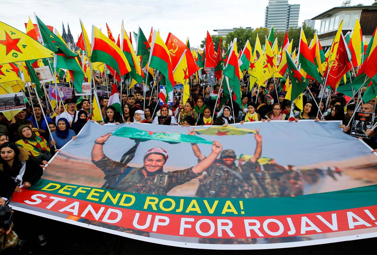 Kurdish protesters hold banner and flags at a demonstration against Turkey's military action in northeastern Syria, in Cologne, Germany, October 12, 2019. REUTERS/Thilo Schmuelgen