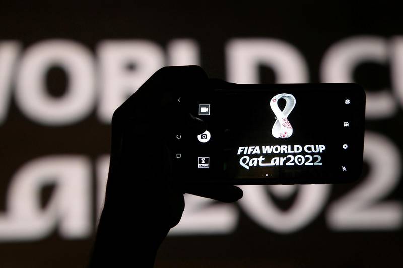 FILE PHOTO: A man takes a picture of the tournament's official logo for the 2022 Qatar World Cup as displayed on the wall of amphitheater, in Doha, Qatar, September 3, 2019. REUTERS/Naseem Zeitoun/File Photo