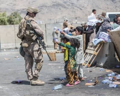 Children playfully squirt a US Marine with water during an evacuation at Hamid Karzai International Airport, Kabul. Reuters
