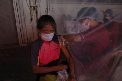 A health worker administers a vaccine shot to a Naga woman in Imphal, India.