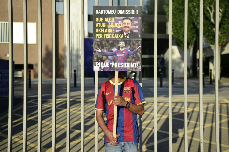 A Barcelona fan holds a placard calling for the resignation of club president Josep Maria Bartomeu. AFP