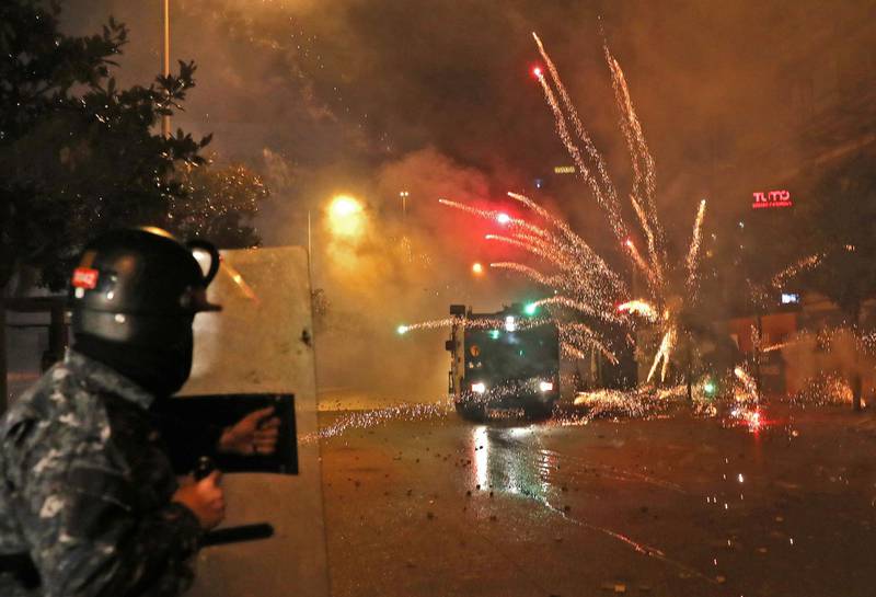 Supporters of Lebanon's Shiite Hezbollah and Amal groups hurl fireworks at security forces in central Beirut. AFP