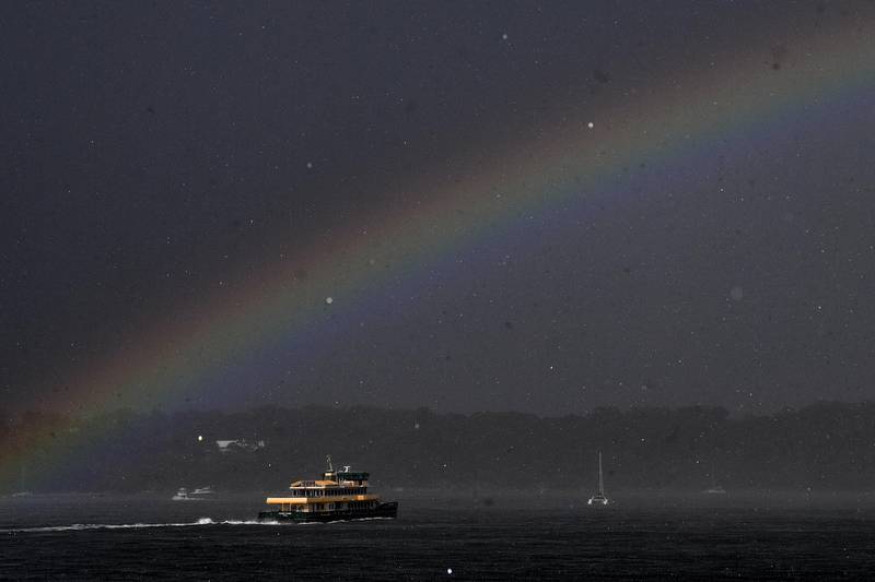 A Sydney ferry is seen under a rainbow during a storm in Sydney, New South Wales. EPA