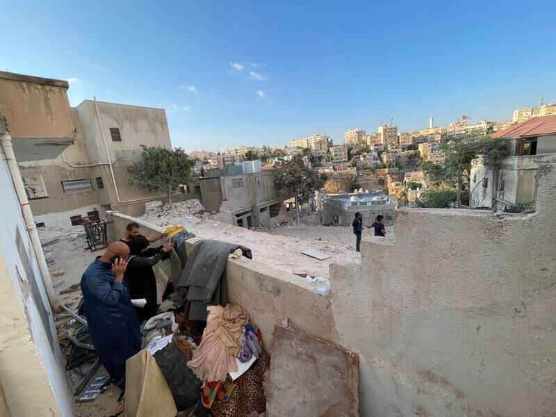 People at the site of a collapsed building in Amman sift through the belongings of their relatives left by demolition crews. Khaled Yacoub Oweis / The National