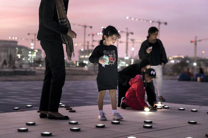 ABU DHABI, UNITED ARAB EMIRATES - JANUARY 9, 2019. Volunteers set up a 20mx20m light installation, comprised of 2,000 solar lanterns, arranged to reveal the Zayed Sustainability Prize logo.Following a month-long, five-country, transcontinental journey, the Zayed Sustainability Prizes Guiding Light campaign arrived to Abu Dhabi today. (Photo by Reem Mohammed/The National)Reporter: Section:  NA