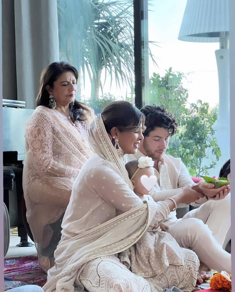 Nick Jonas and Priyanka Chopra perform a puja as Malti Marie and Madhu Chopra look on. 
