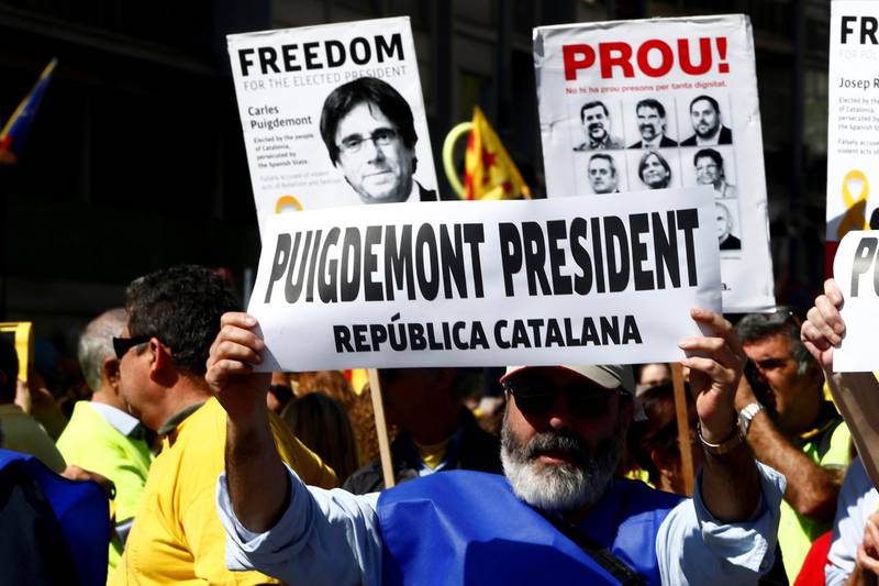 A man holds a poster calling for the exiled separatist leader Carles Puigdemont to be president of the Catalan Republic. EPA/Quique Garcia