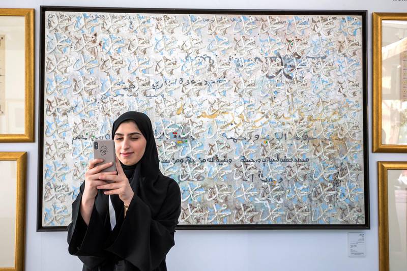ABU DHABI, UNITED ARAB EMIRATES - A local woman taking photos of artwork at the Al Burda Festival, Shaping the Future of Islamic Art and Culture at Warehouse 421, Abu Dhabi.  Leslie Pableo for The National for Melissa Gronlund’s story