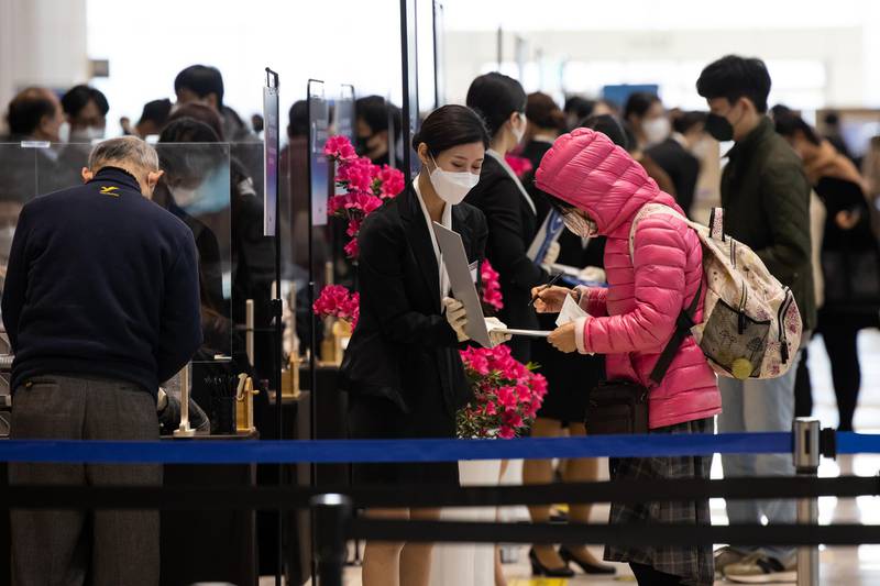 A member of event staff wearing a protective mask registers an attendee arriving for the Samsung Electronics Co. annual general meeting at the Suwon Convention Center in Suwon, South Korea. Bloomberg