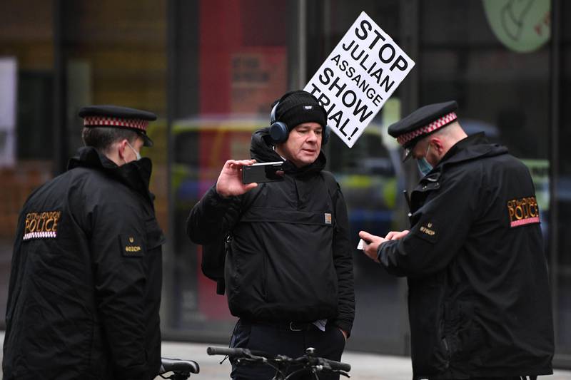 Police speak to a man who appears to be filming as Julian Assange is taken to the Old Bailey. Getty Images
