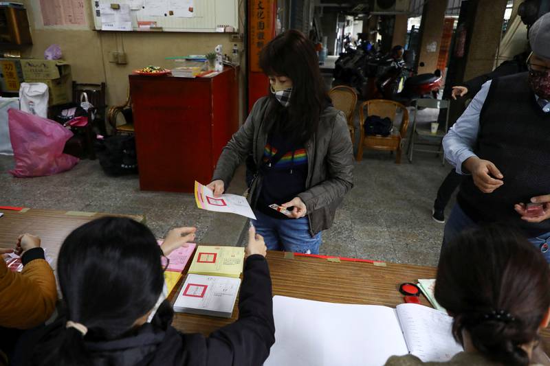 A woman receives ballots at a polling station in Taiwan. Reuters
