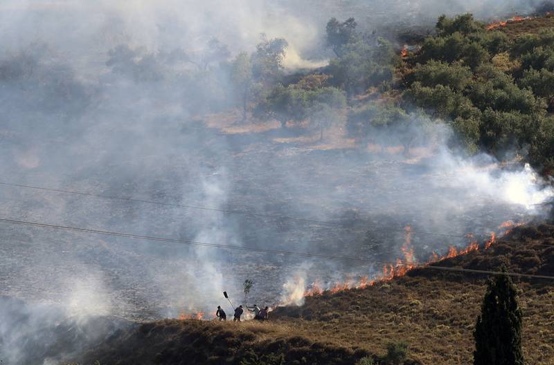 Palestinians extinguish a fire in a field around the village of Burin, south of Nablus, on June 29, 2021. AFP