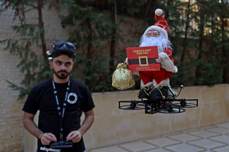 A man controls a drone fixed to a Santa Claus figurine, in Aintoura, north of the Lebanese capital Beirut. AFP