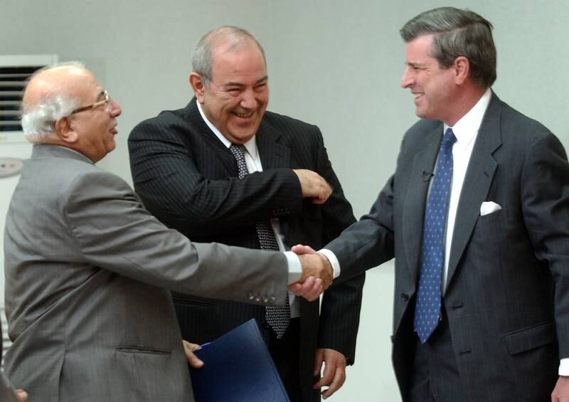 June 28, 2004: US administrator in Iraq Paul Bremer (R), Iraqi Prime Minister Ayad Allawi (C) and the country's most senior judge Midhat Mahmoud (L) smile as the US transfers sovereignty to Iraq in Baghdad. Mr Allawi calls the event 'a historic day' and says that Iraq was 'capable of controlling the security situation'. Reuters