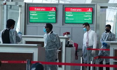 Gate staff wearing protective gear due to the coronavirus pandemic wait for boarding for an Emirates flight to Frankfurt, Germany, at Dubai International Airport's on Wednesday, June 10, 2020. AP Photo