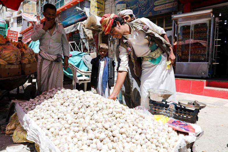 A vendor selling garlic waits for customers on a street in Sanaa.