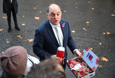 Mr Wallace sells poppies to members of the media as he leaves a Cabinet meeting in Downing Street in November. Getty Images