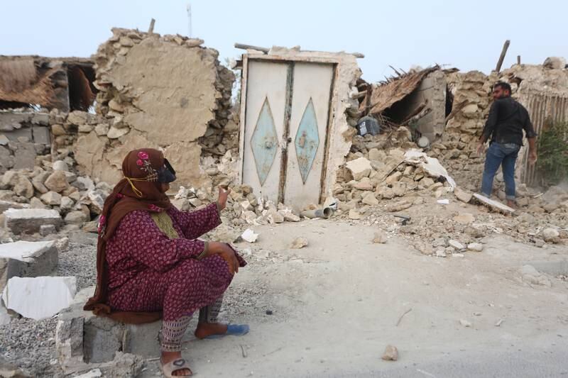A woman sits outside the rubble of her house in the aftermath of a powerful earthquake, in Sayeh Khosh, southern Iran.  At least five people were killed by Saturday's 6.1-magnitude quake. EPA 