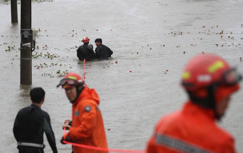 South Korean rescue workers rescue a man from a flooded riverside park in Ulsan as Typhoon Hinnamnor battered South Korea's southern provinces. AFP