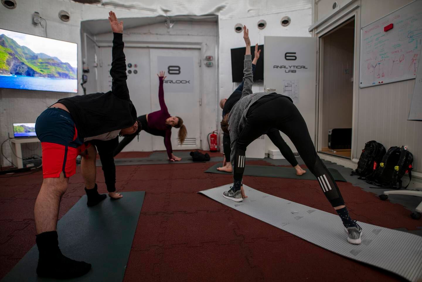 Egyptian astronaut Sara Sabry leads a group of astronaut trainees on a yoga workout at the LunAres analog space station in Poland. For astronauts, exercise is essentially to combat the drop in bone density and muscle atrophy they experience off-planet. Photo: LunAres Research Station