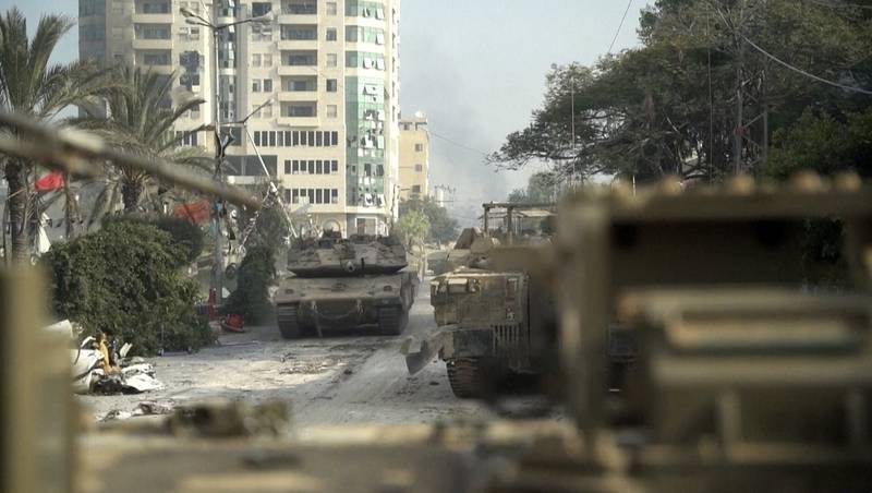 An Israeli tank ploughs down a street in Gaza city. AP
