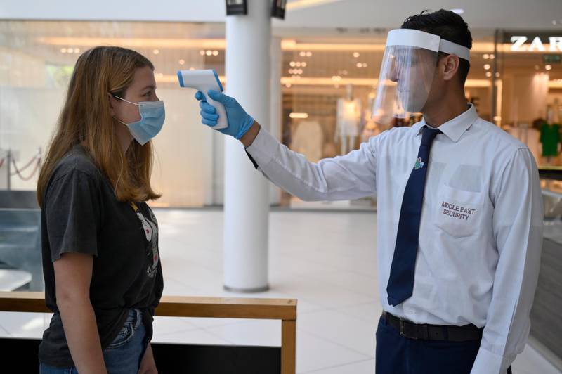 A security guard wearing a face mask checks the body temperature of a customer in a shopping mall in Dbayeh, northern Beirut, Lebanon.  EPA