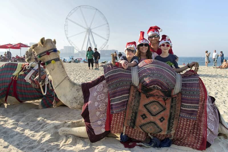 Dubai, United Arab Emirates, December 25, 2017:    American expatriates Matt Hubbard, his wife Lori and their children Olivia, 8, left and Gage,10, with a camel on Jumeirah Beach Residence on Christmas Day in the Dubai Marina area of Dubai on December 25, 2017. Christopher Pike / The National

Reporter:  N/A
Section: News