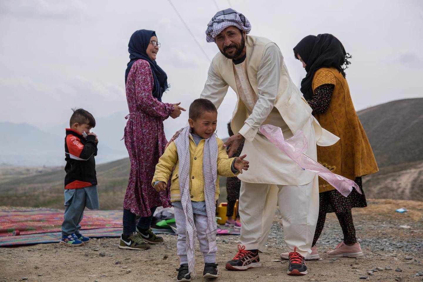 A father teachers his son how to fly a kite on Nowruz in Kabul. 