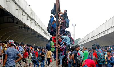 People climb a structure to sit atop an overcrowded train at the Kamlapur Railway Station in Dhaka, Bangladesh. EPA