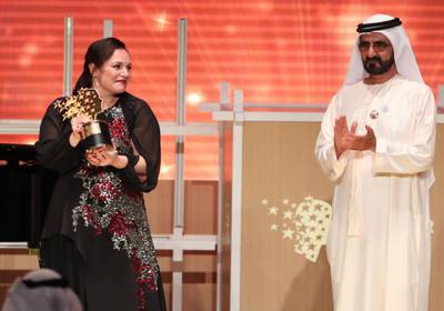 British teacher Andria Zafirakou (L) receives the "Global Teacher Prize" from Sheikh Mohammed bin Rashid al-Maktoum, Vice-President and Prime Minister of the UAE and Ruler of Dubai during an award ceremony in Dubai on March 18, 2018.  
Zafirakou who  was among ten finalists chosen from 179 countries, won one million dollars of prize money. / AFP PHOTO / KARIM SAHIB