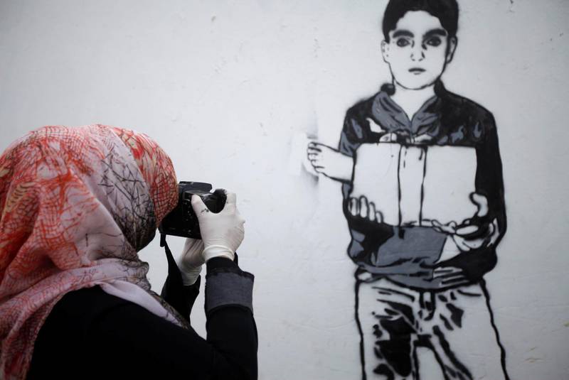 Haifa Subay takes a photo of her work in Sanaa. Mohamed Al Sayaghi / Reuters