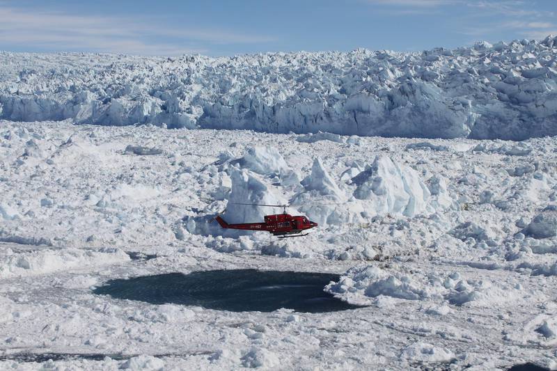 Scientists monitor glaciers in Greenland from a helicopter. Courtesy Denise Holland