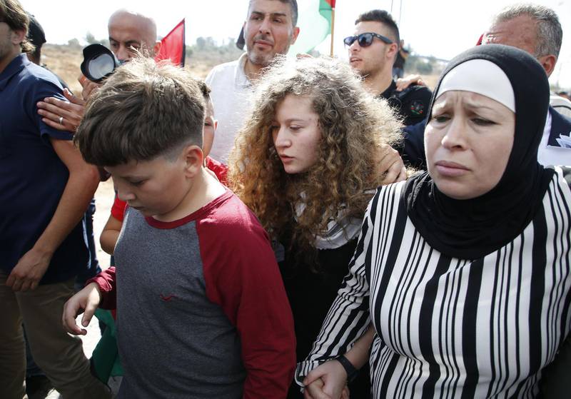 Ahed Tamimi walks with her mother and brother upon her release from prison. AFP