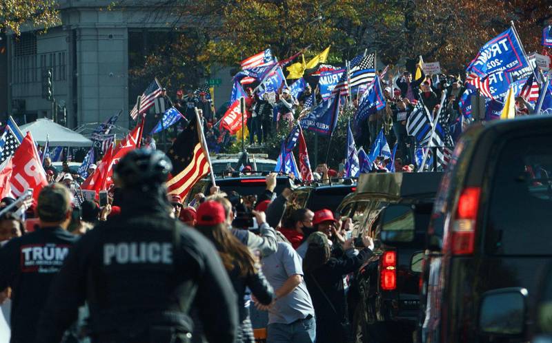 The motorcade of US President Donald Trump drives past supporters holding a rally in Washington, DC.  AFP