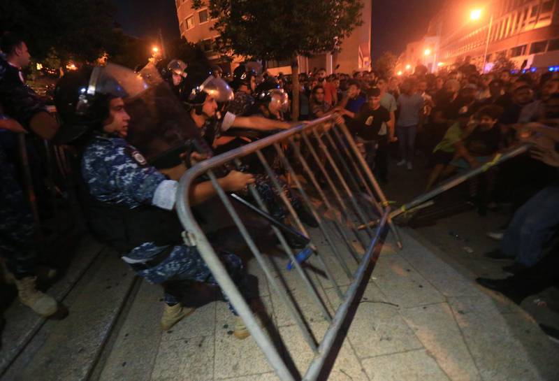 Demonstrators clash with police during a protest against a government decision to tax calls made on messaging applications on October 17, 2019 outside the government palace in Beirut. - Hundreds took to the streets across Lebanon on October 17 to protest dire economic conditions after a government decision to tax calls made on messaging applications sparked widespread outrage. (Photo by STRINGER / AFP)