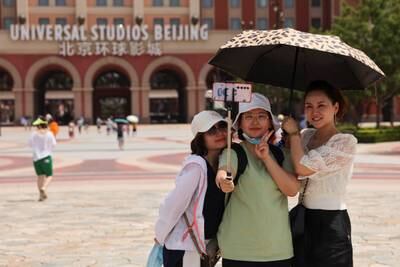 Tourists take selfies in front of the Universal Studios theme park in Beijing, China. Reuters