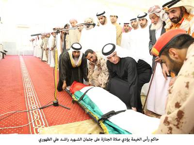Sheikh Saud bin Saqr Al Qasimi, Ruler of Ras Al Khaimah, helps lay the body of WO Rashid Ali Mohammed Al Duhouri down during funeral prayers in Ras Al Khiamah. Wam