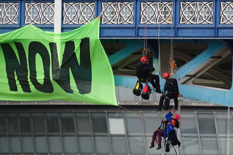 Police officers remove activists who were protesting on Tower Bridge. PA