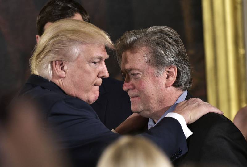 Former US President Donald Trump (left) congratulates Steve Bannon, former Senior Counselor to the President, during the swearing-in of senior staff in the White House in Washington on January 22, 2017. AFP