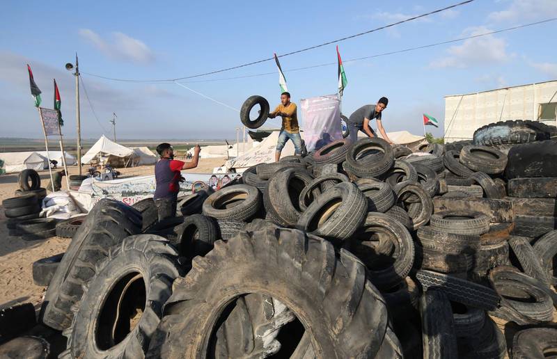 A man carries tyres to be burnt as Palestinians prepare to demonstrate along the border with the Gaza strip, east of Jabalia. Mohammed Abed / AFP