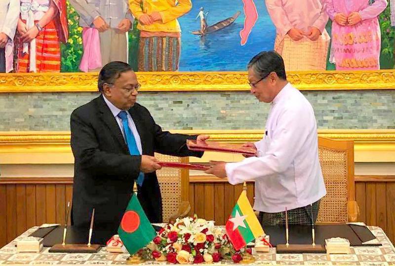 In this image provided by Myanmar's Ministry of Information, Myanmar's Union Minister for the Office of the State Counsellor  Kyaw Tint Swe, right, and Bangladesh Foreign Minister Abdul Hassan Mahmud Ali exchange notes after signing the Arrangement on Return of Displaced Persons from Rakhine State in Naypyitaw, Myanmar, Thursday, Nov. 23, 2017. Myanmar and Bangladesh signed an agreement on Thursday covering the return of Rohingya Muslims who fled across their mutual border to escape violence in Myanmar's Rakhine state. (Myanmar Information Ministry via AP)