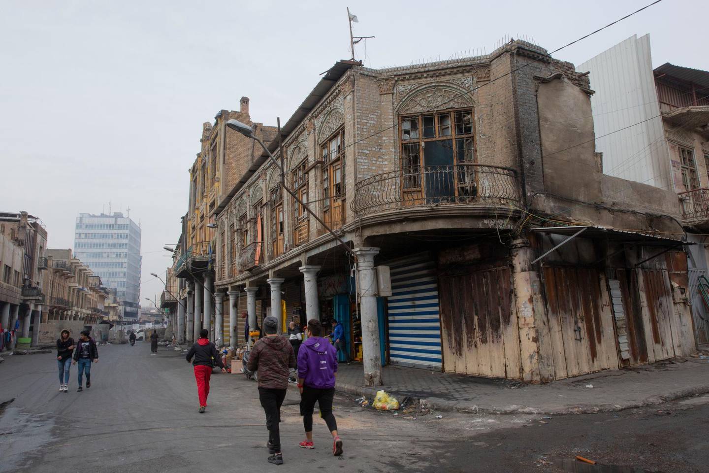 In this Monday, Dec. 16, 2019 photo, with the major part of the shops are closed, cement blocks close the commercial and historic al-Rasheed street, in the center of Baghdad, Iraq.  With Iraq's leaderless uprising now in its third month, the protracted street hostilities, internet outages, blocked roads and a general atmosphere of unease are posing risks to Iraq's economy. In particular, the unrest has set back the most fragile segment of the country's economy, the private sector, where business owners have faced losses from damage to merchandise and disruptions of markets and from consumers reeling in their spending out of fear for the future. (AP Photo/Nasser Nasser)