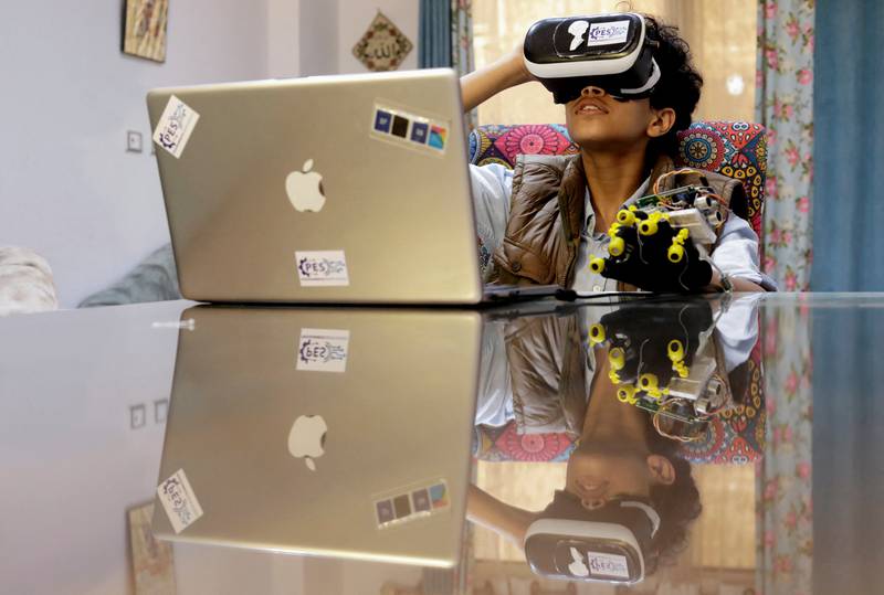 Wearing a virtual reality headset and black and yellow wired gloves. The Egyptian teenager is hoping to build his own version of the metaverse, allowing people to one day shop, attend classes, or even conduct experiments online.