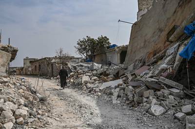 A man walks through a destroyed neighbourhood in Al Mastuma. AFP