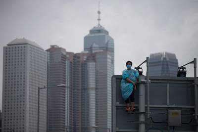 A protester keeps a look out from the top of a traffic signage pole. EPA