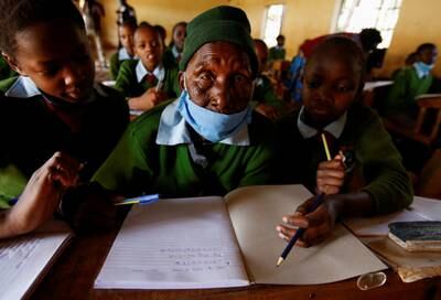 Priscilla Sitienei, a 98-year-old primary school student, gets help from her classmates in Ndalat, Kenya. Reuters